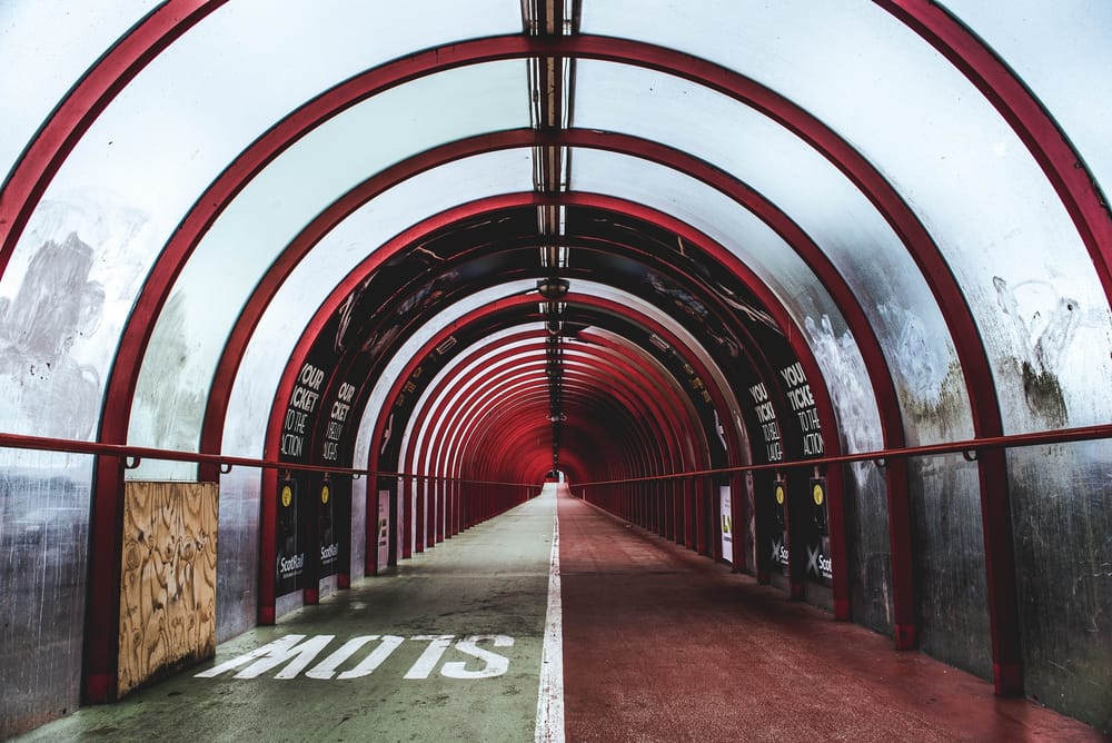 Covered bridge with SLOW sign painted on one side by Ryan Johnston