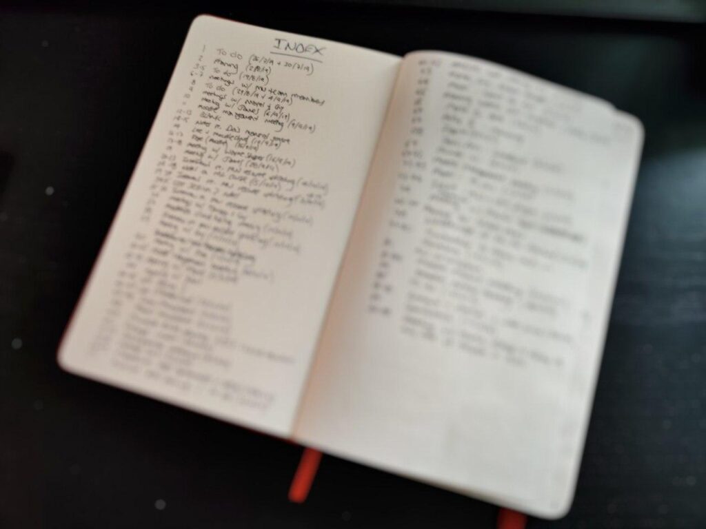 Handwritten index page in front of notebook