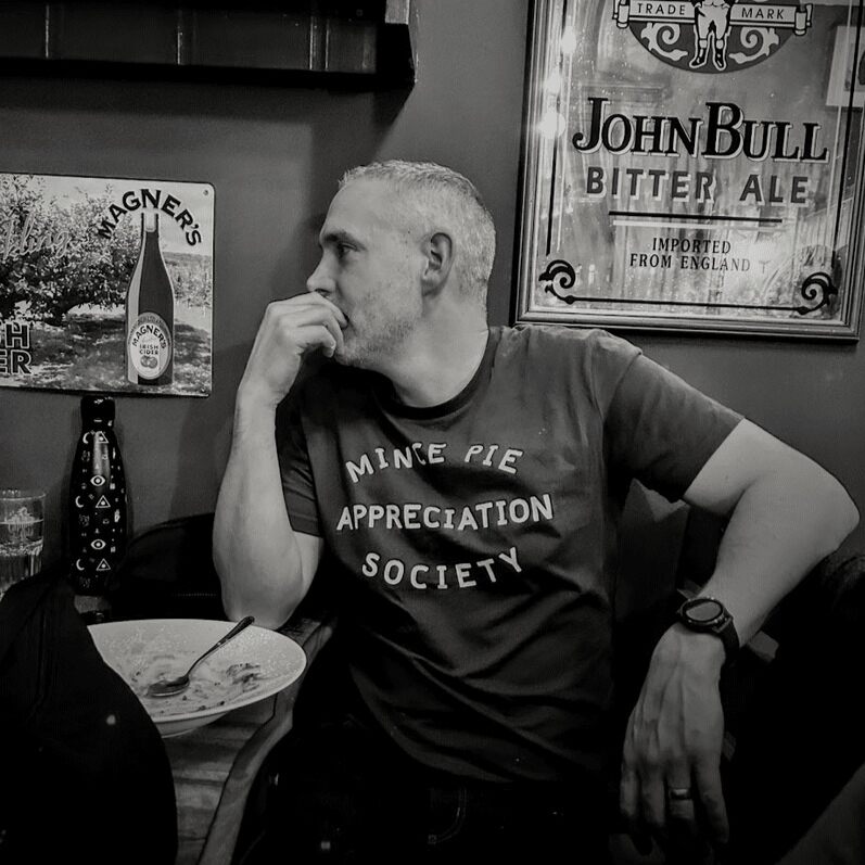 Photo of Doug in Irish pub wearing 'Mince Pie Appreciation Society' to-shirt. Original photo taken by Julie Keane