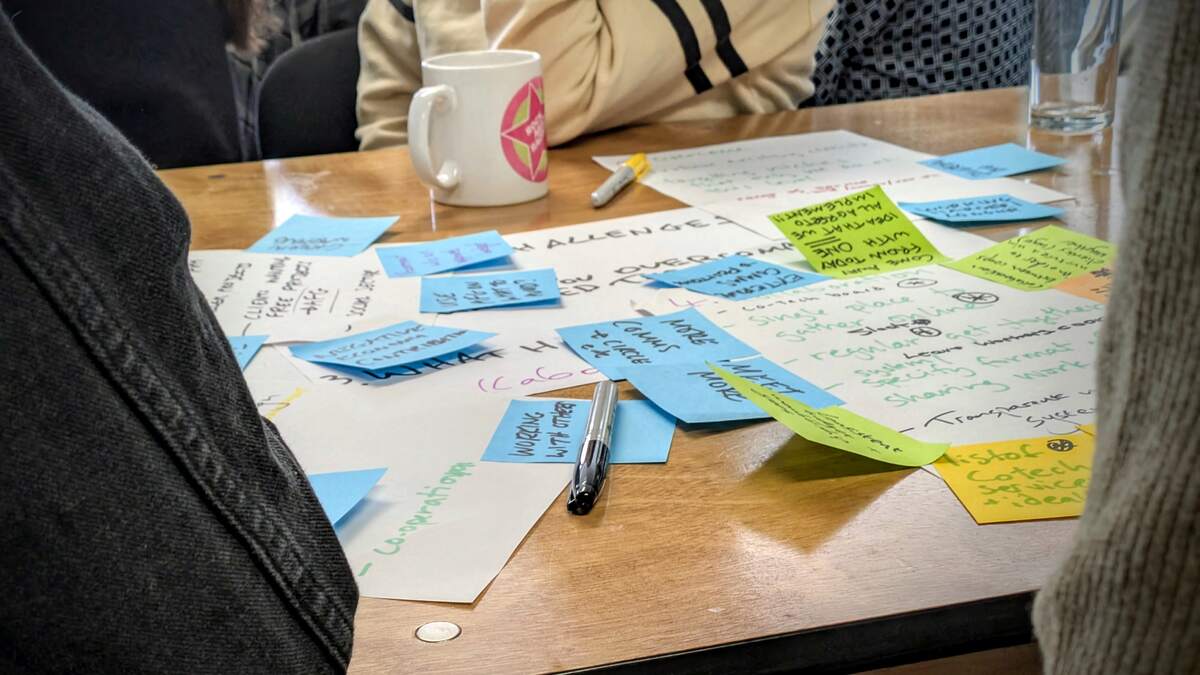 Table with mug, paper, sticky notes, and sharpies